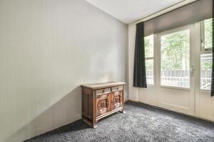 A room with a small cabinet and a window photo