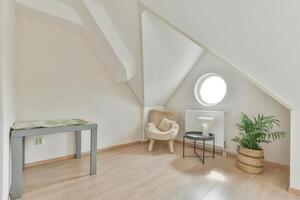 An attic room with a table and chair in it photo