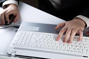 human hands on the notebook keyboard and mouse photo