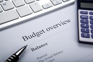 document with title budget overview and keyboard, calculator photo
