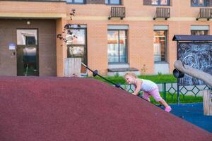 Young girl playing and sliding down a slide photo