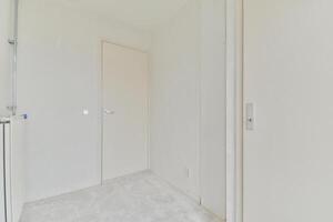 An empty room with white walls and a door photo