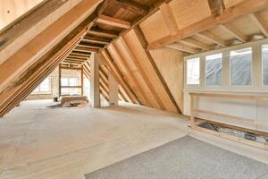 An attic with wood beams and a window photo