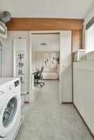 A laundry room with a washing machine and a desk photo