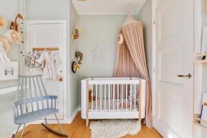 A baby's room with a crib, rocking chair and a rocking horse photo