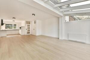 An empty room with wooden floors and skylights photo