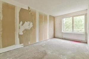An empty room with a wall covered in drywall photo
