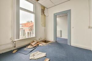 An empty room with a broken window and a door photo