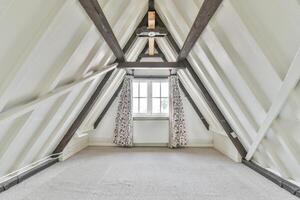 A white attic with a window and a ceiling photo