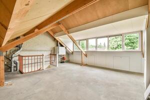 An attic with a wooden ceiling and a window photo