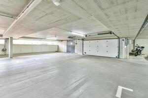 An empty garage with a white wall and a door photo