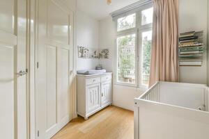 A small room with a white cabinet and a window photo