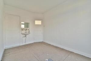 A bathroom with a sink and toilet in a white room photo