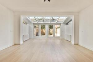 A large empty room with a skylight and wooden floors photo