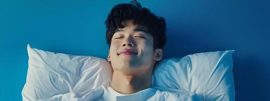 Smiling Hallyu Man Sleeping in Modern Neo Pop Costume on Blue Background photo