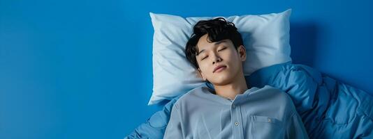 Smiling Hallyu Man Sleeping in Modern Neo Pop Costume against Blue Background photo