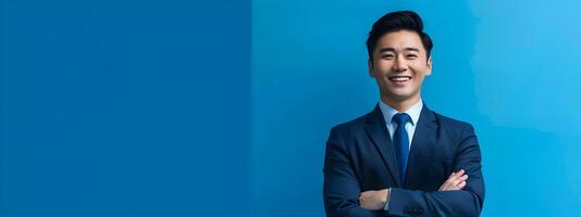 Successful Asian Businessman Smiling in Corporate Attire with Blue Background photo