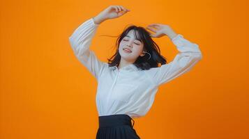 Asian Businesswoman Dances with Vibrant Costume on Orange Background photo