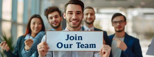Group of Smiling Professionals Holding Join Our Team Sign in Office Setting photo