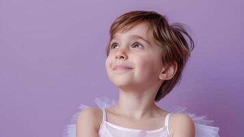 A young girl in a tutu is looking up photo