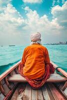 Man in Orange Turban Sitting in Wooden Boat on Peaceful Waterway photo