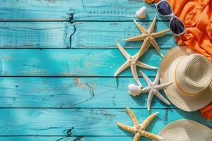 Summer background with hat, starfish and orange scarf on blue wooden background photo