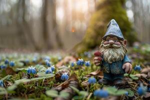 A gnome is standing in the forest with blue flowers photo