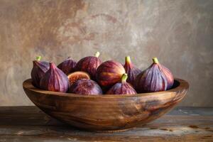 A wooden bowl filled with figs on a table photo