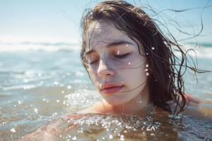 A woman with her eyes closed in the ocean photo