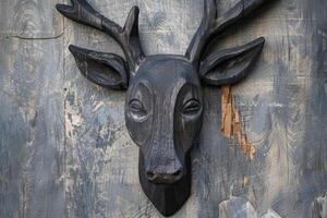 A wooden deer head mounted on a wall photo