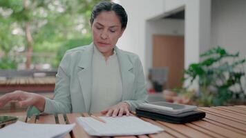 Frustrated businesswoman dissatisfied with work and answering incoming phone call and talking with dissatisfaction in outdoor. Working with tablet and taking notes. Deadline. Stress. video