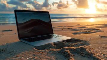 A laptop on the beach at sunset photo
