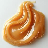 Drizzle of caramel sauce creating an abstract pattern on a pristine white background smooth and glossy photo