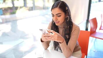 Persian woman using smartphone sitting on urban steps video