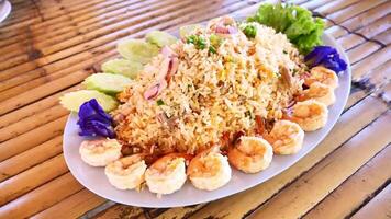 A plate of rice and shrimp with cucumbers and tomatoes video