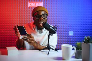 African american blogger unboxing new smartphone and recording on camera photo