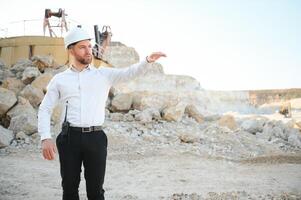 Extraction of stone. Male worker next to stone quarry. Engineer at construction site photo