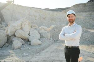 Extraction of stone. Male worker next to stone quarry. Engineer at construction site photo