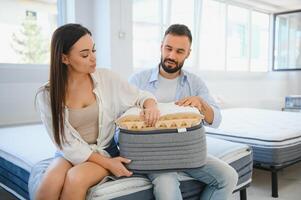 A young couple is choosing bedding at a bed, mattress and pillow store. Everything for a comfortable sleep photo
