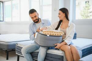 A beautiful young couple chooses a new mattress in a store photo