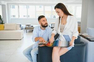 Focus on samples of colored fabrics for upholstered furniture. Overhead view of couple choosing color and fabric texture for upholstery sofa in the home. Interior design concept. photo