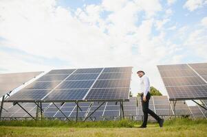 The solar farm, solar panel with engineer check the operation of the system, Alternative energy to conserve the worlds energy, Photovoltaic module idea for clean energy production. photo