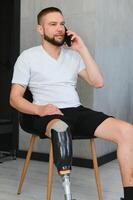 Portrait of man with prosthetic leg at home, copy space photo
