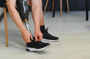 Closeup of unrecognizable man with bionic prosthetic leg at home indoors, copy space photo
