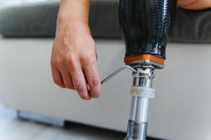 Close-up elevated view of a man adjusting the screws on an artificial prosthetic leg photo