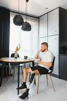 Portrait of man with prosthetic leg reading book while relaxing at home, copy space photo