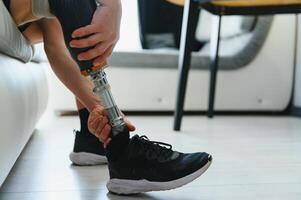 Closeup of unrecognizable man with bionic prosthetic leg at home indoors, copy space photo