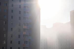 High rise apartment buildings with sunlight shining through the foggy atmosphere. photo