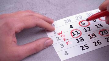 Plan a work week. Circle and strike through calendar dates. Write planning day video