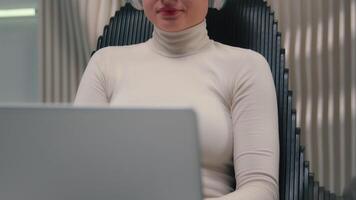 Female woman businesswoman hacker user programmer coder in headphones studying laptop in chair futuristic cyber space work coding business data security Caucasian girl gamer play online game computer video